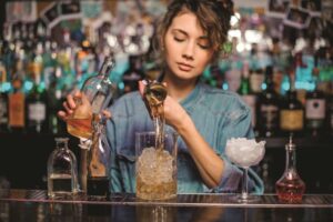 Qualified female bartender with RSA making cocktails at a bar