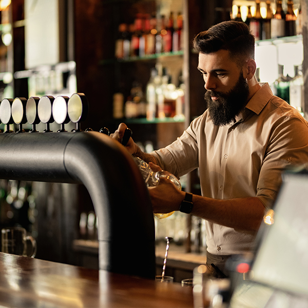 male-bartender-pouring-beer-at-a-bar